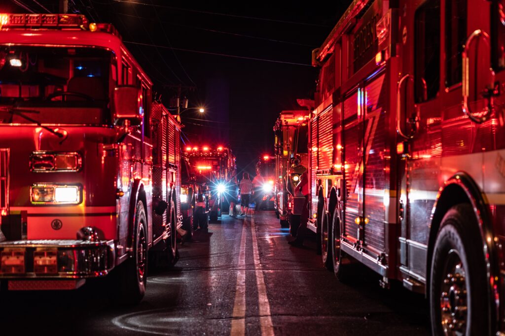 Fire trucks at an emergency with lights on.
