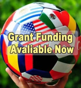 A soccer ball covered with different flags. The words "Grant Funding Available Now" are over it